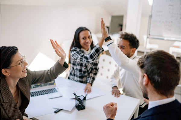 A busy office with employees giving high fives